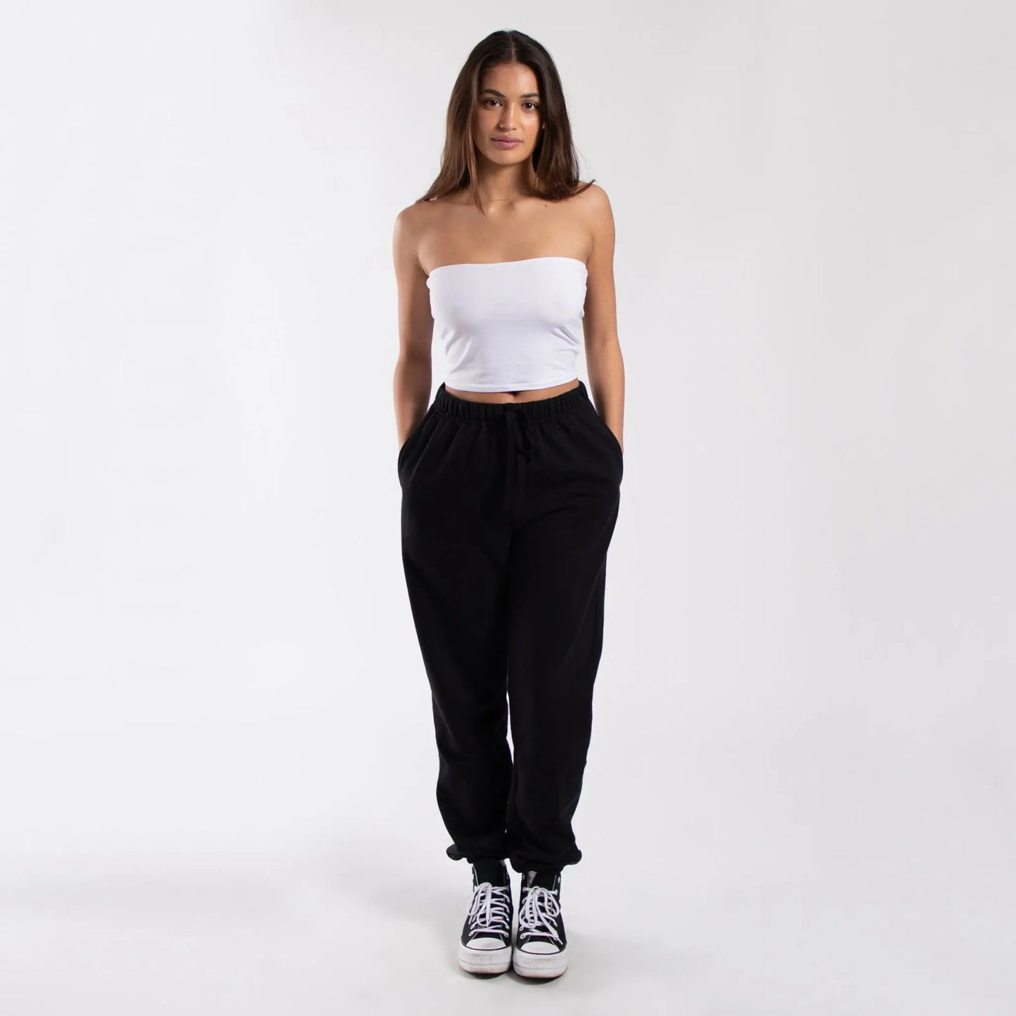 Black drawstring jogger pants with pockets and white Converse sneakers for women