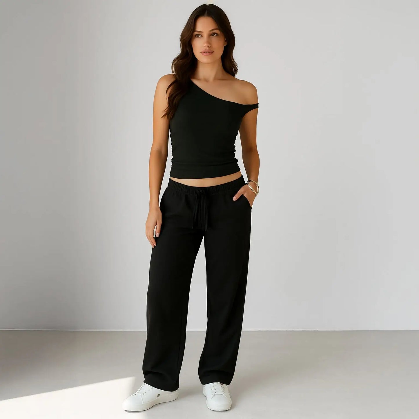 Black one-shoulder crop top with matching sweatpants and white sneakers for info otlapparel