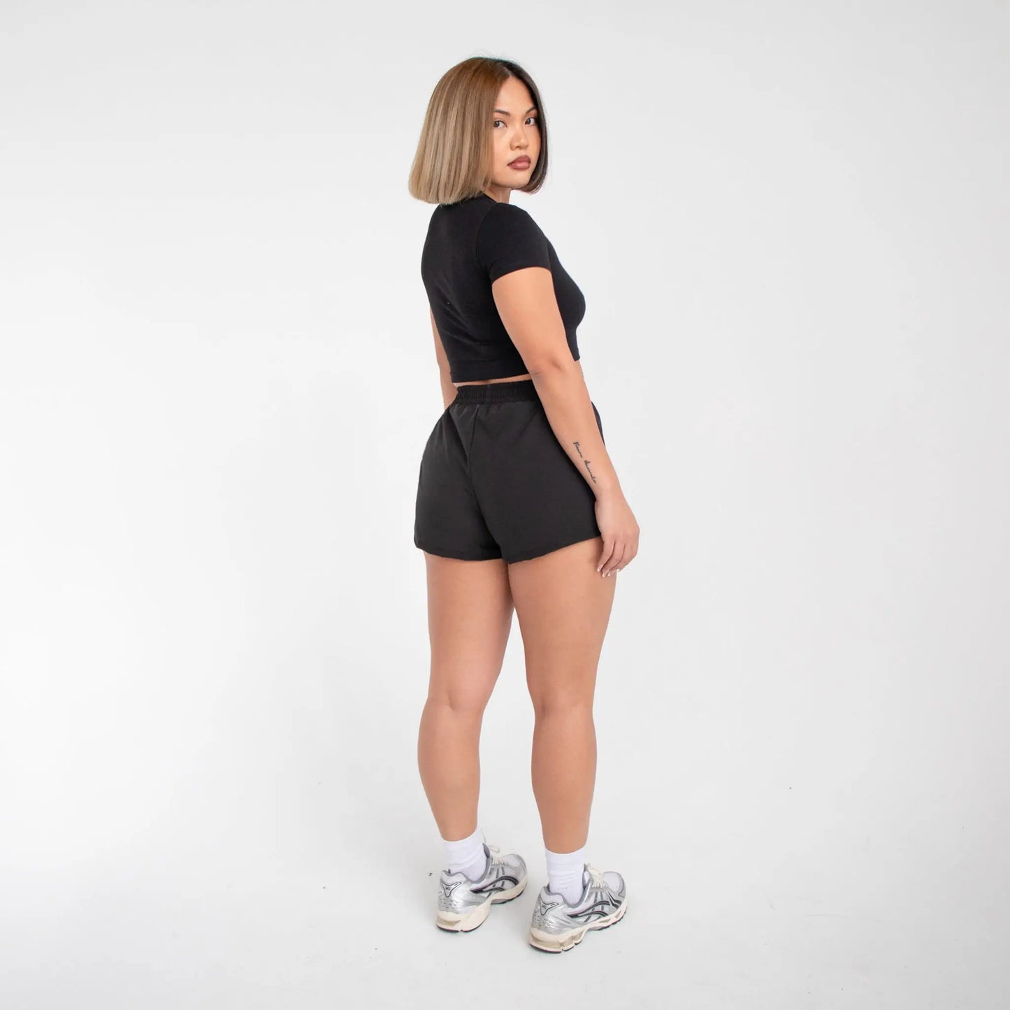 Black cotton T-shirt with silver metallic sneakers and white socks for athletic shorts style