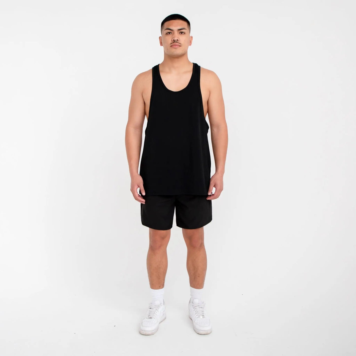 Black tank top with white sneakers paired with Men’s Athletic Shorts 1007 for activewear