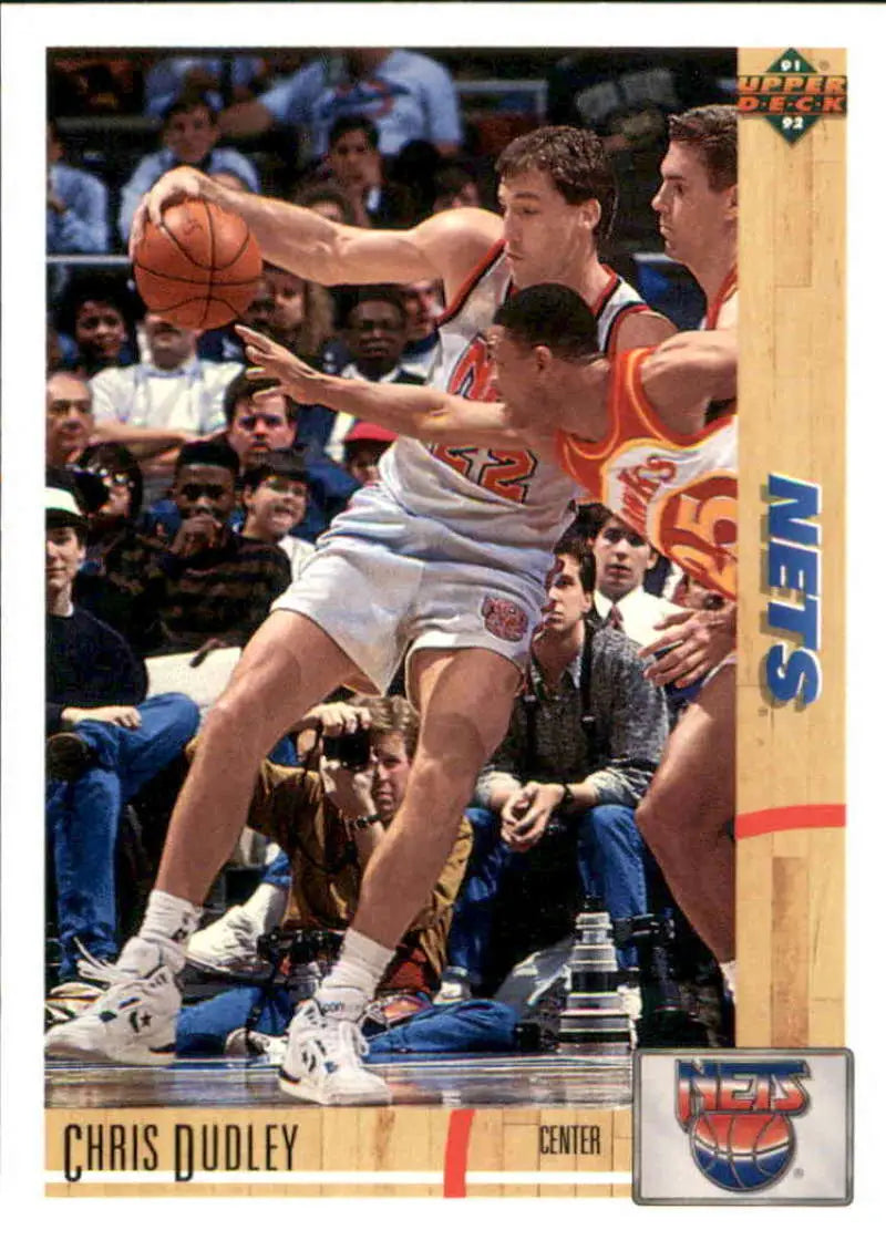 Chris Dudley in a white Jersey Nets jersey reaching for the ball on a basketball card