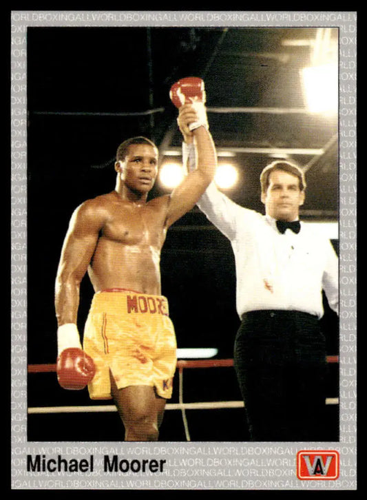 Victorious Michael Moorer in yellow shorts with referee after a match on boxing card