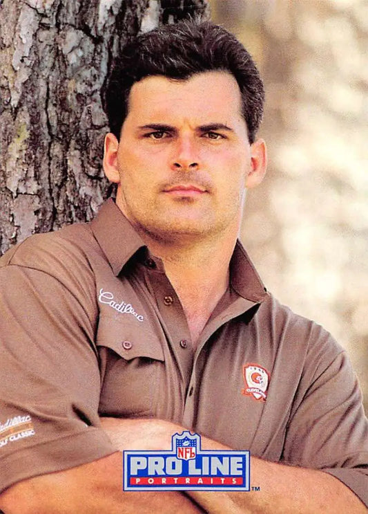 Man in brown Cleveland Browns Pro Line uniform shirt leaning by a tree