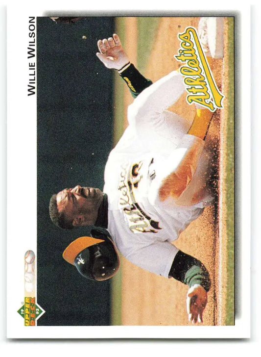 Baseball player in white Oakland Athletics uniform sliding into base on Willie Wilson card
