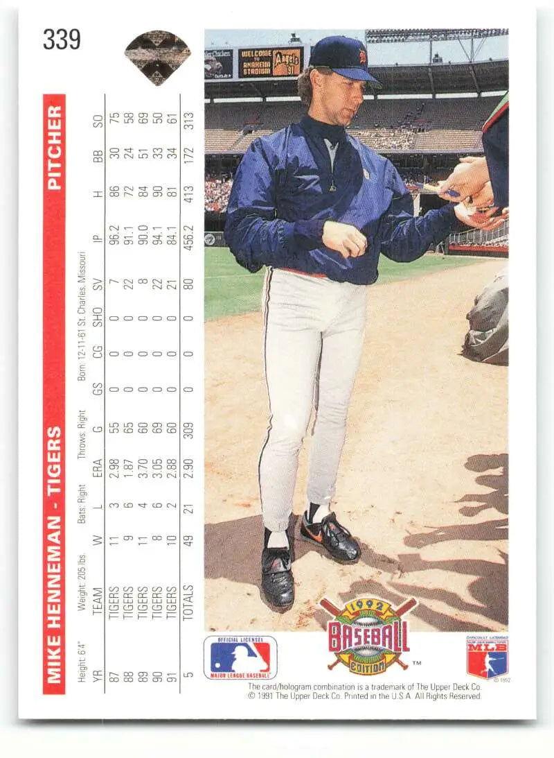 Baseball card of Mike Henneman in navy jacket signing autographs for fans