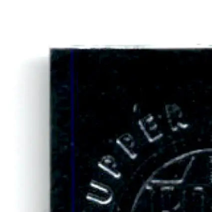 Black glossy rectangular object with UPPER embossed, part of 1996 Upper Deck Racing Road to the Cup Bill Elliott RC7a