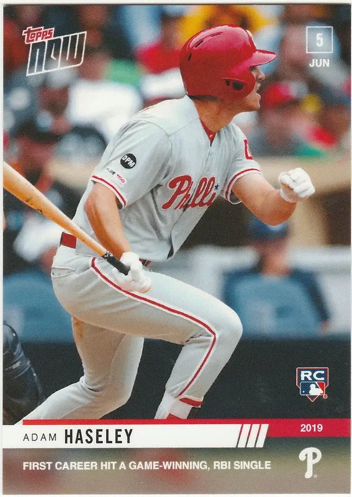 Baseball player Adam Haseley in white Philadelphia Phillies uniform swinging bat