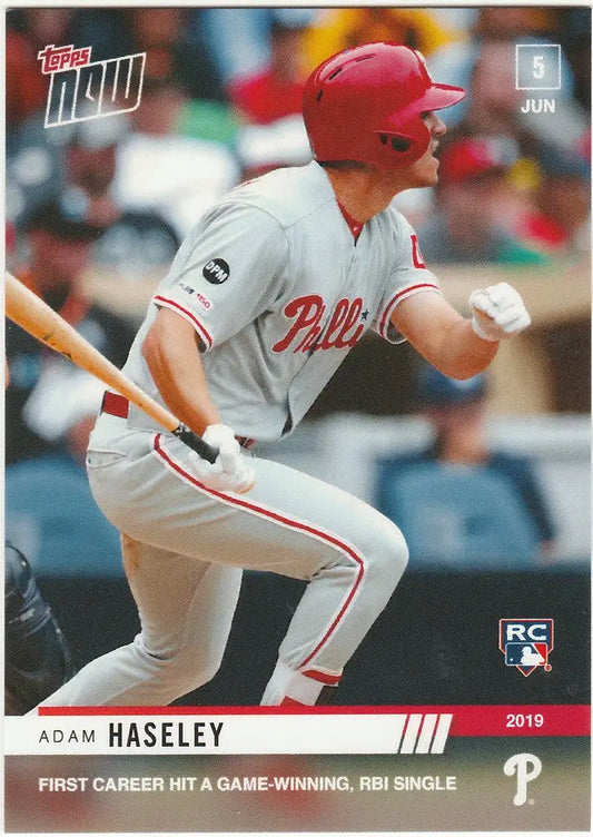 Baseball player Adam Haseley in white Philadelphia Phillies uniform swinging bat