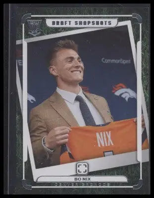 Football trading card featuring Bo Nix in suit holding Denver Broncos jersey from Nix Draft Snapshots
