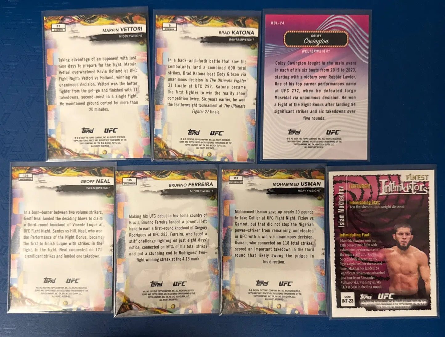 UFC trading cards in protective sleeves featuring Topps Red Shimmer design and fighters