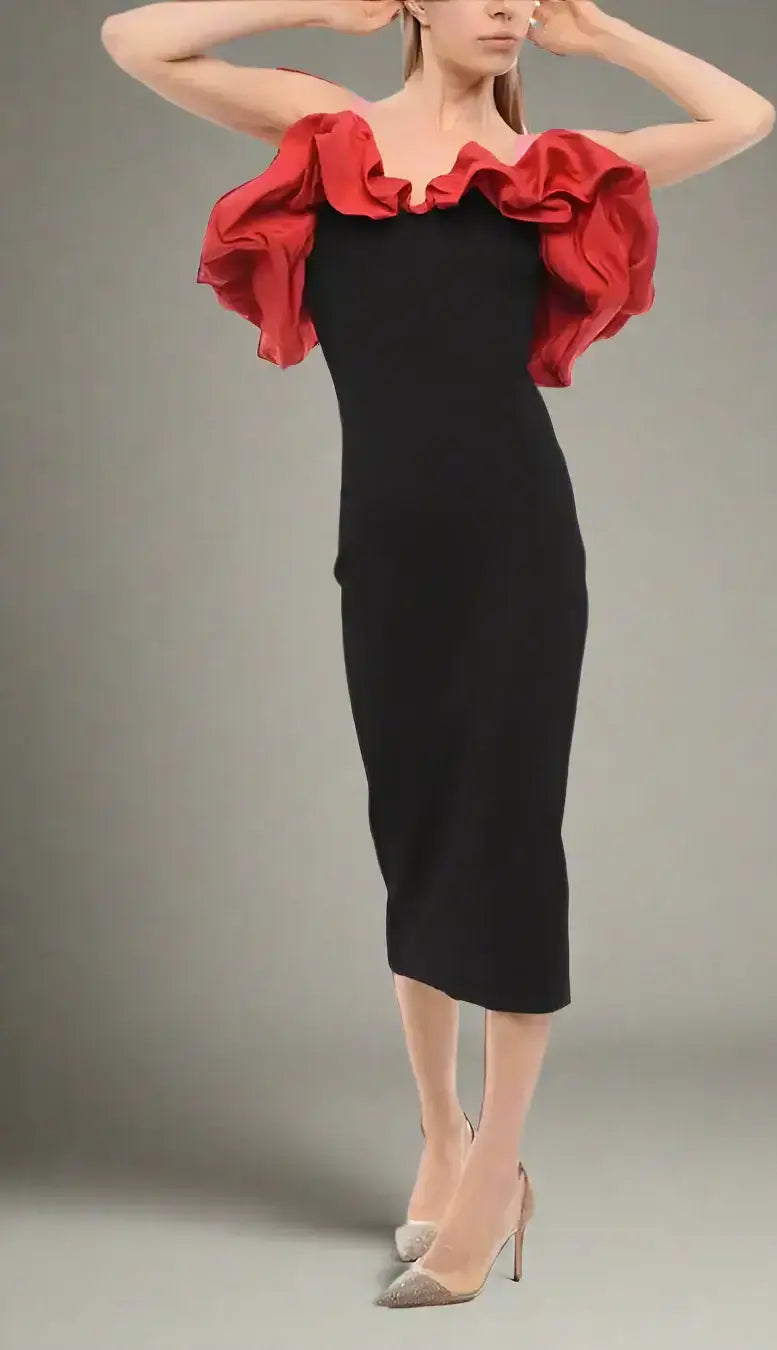 Woman wearing Alexander McQueen knitted black midi dress with red off-the-shoulder ruffle top