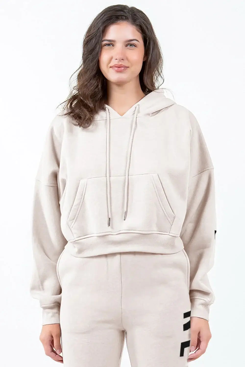 Woman wearing beige cropped hoodie with letter graphic long sleeve design