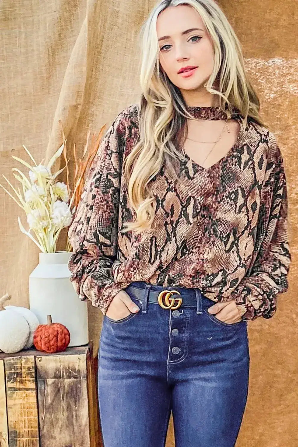 Women’s snake print long-sleeve top with choker neck and V-neckline, paired with jeans