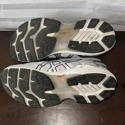 Used white and black running shoes with visible tread on the soles for Women Size 9.5