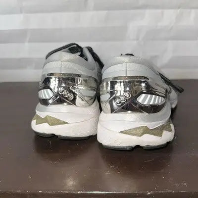 Silver and white running shoes with reflective heel accents for women in size 9.5