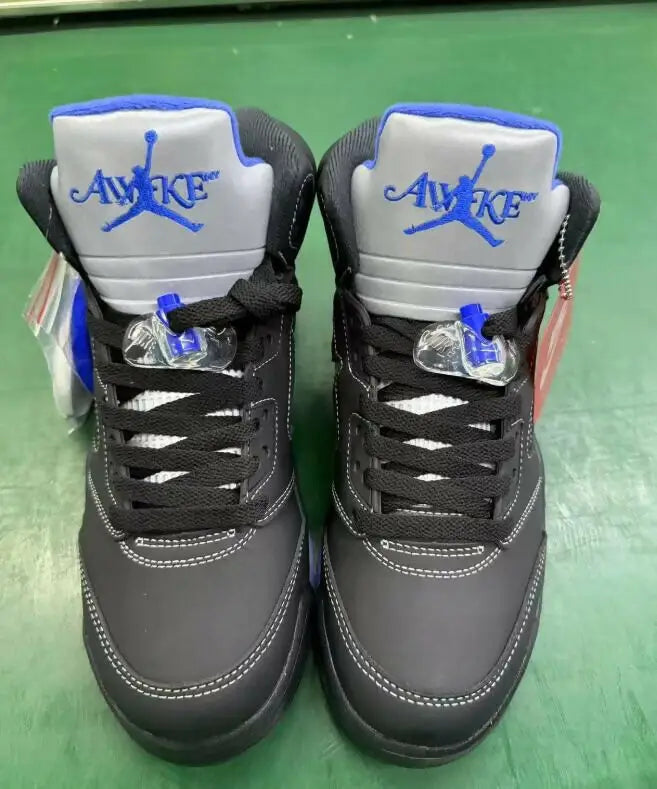 Black and gray Air Jordan 5 sneakers with blue accents from Awake NY x Air Jordan 5 for fast shipping