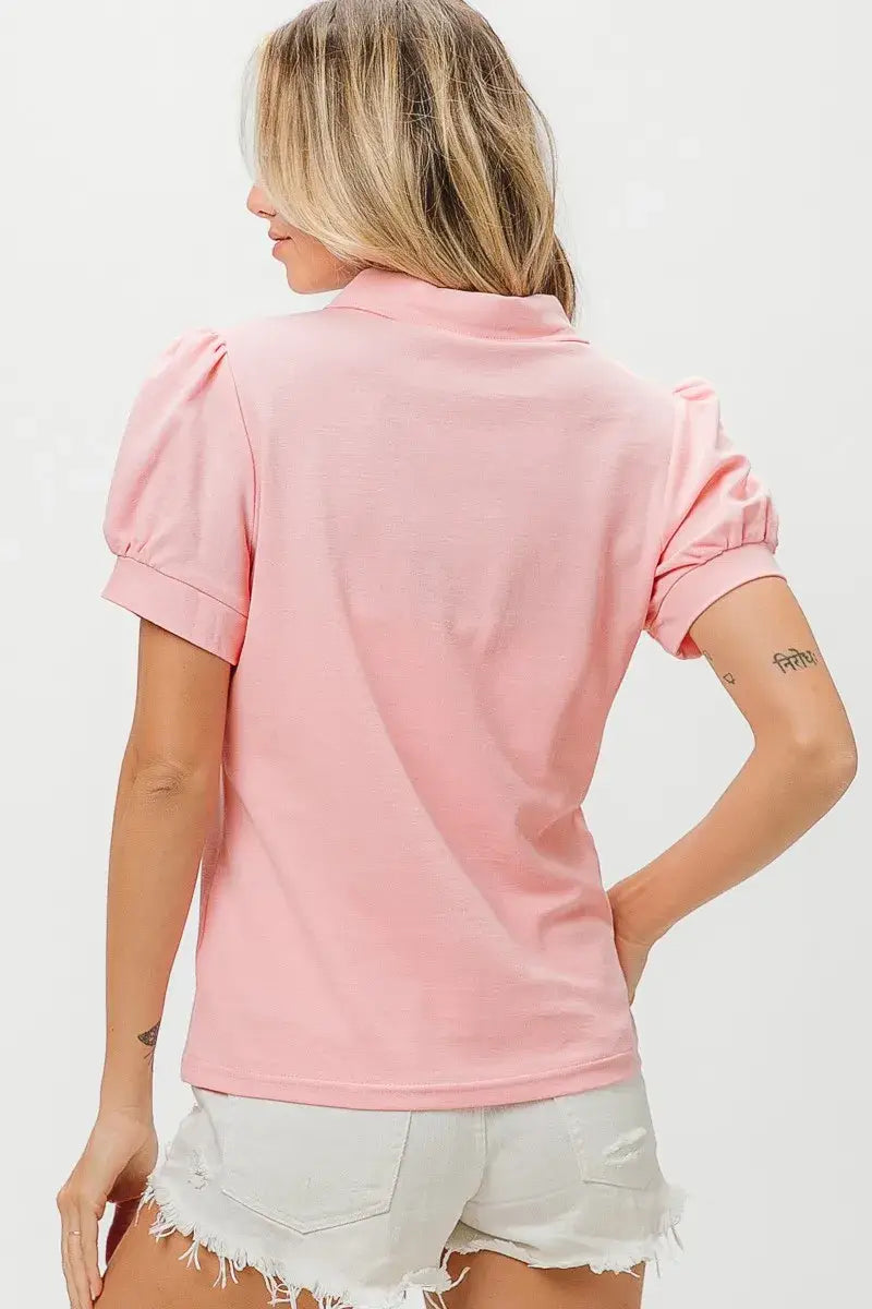 Pink puff sleeve pique polo shirt with high collar paired with white denim shorts