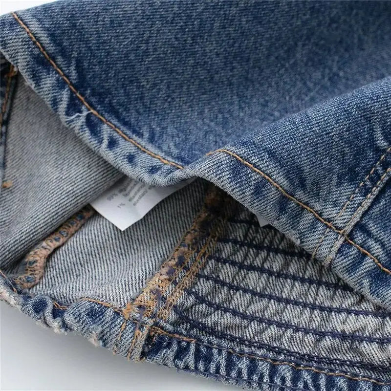 Close-up of blue denim corset top’s hem and inner stitching with patterned elastic section