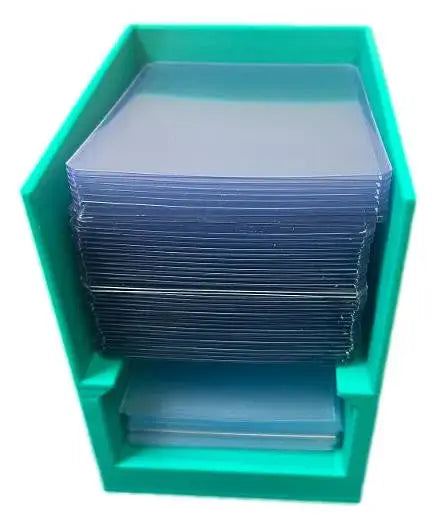 Green Break Buddy plastic box filled with stacks of clear penny sleeves and toploader holders