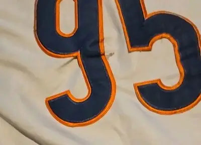 White Chicago Bears jersey with blue and orange numbers showing wear and discoloration