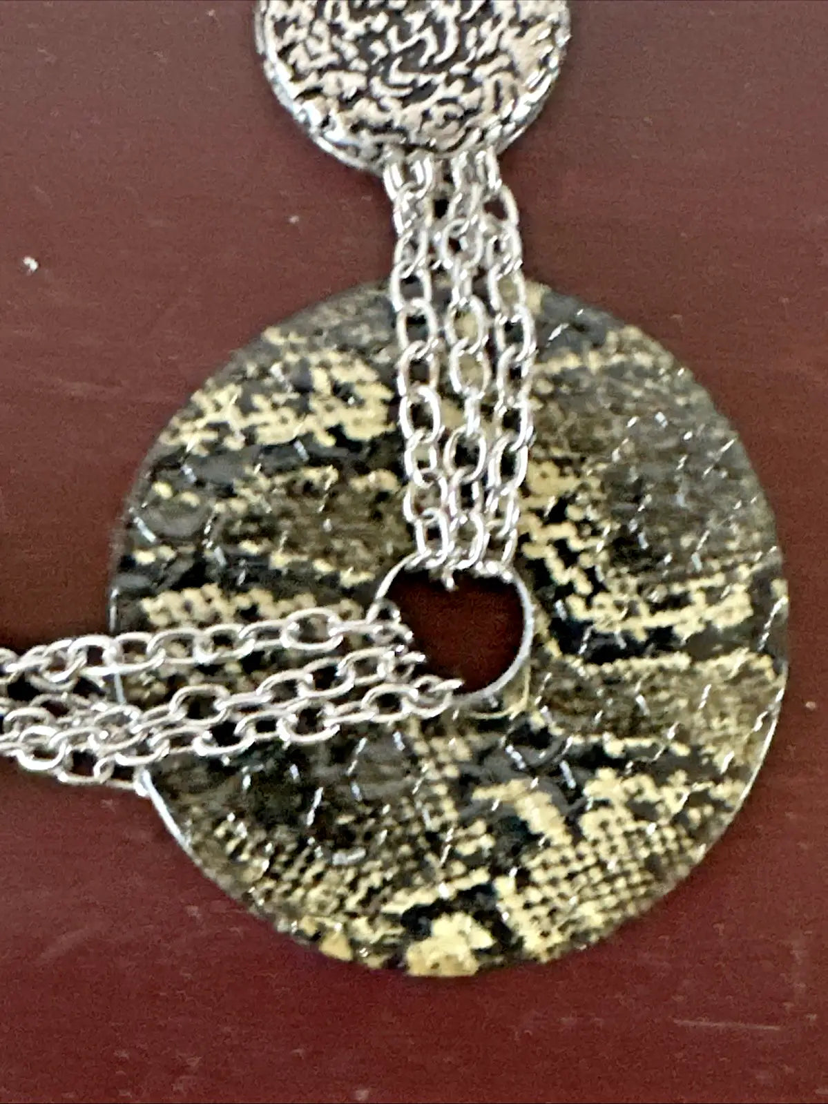 Silver-toned necklace with faux snakeskin pendant and silvertone chain accent