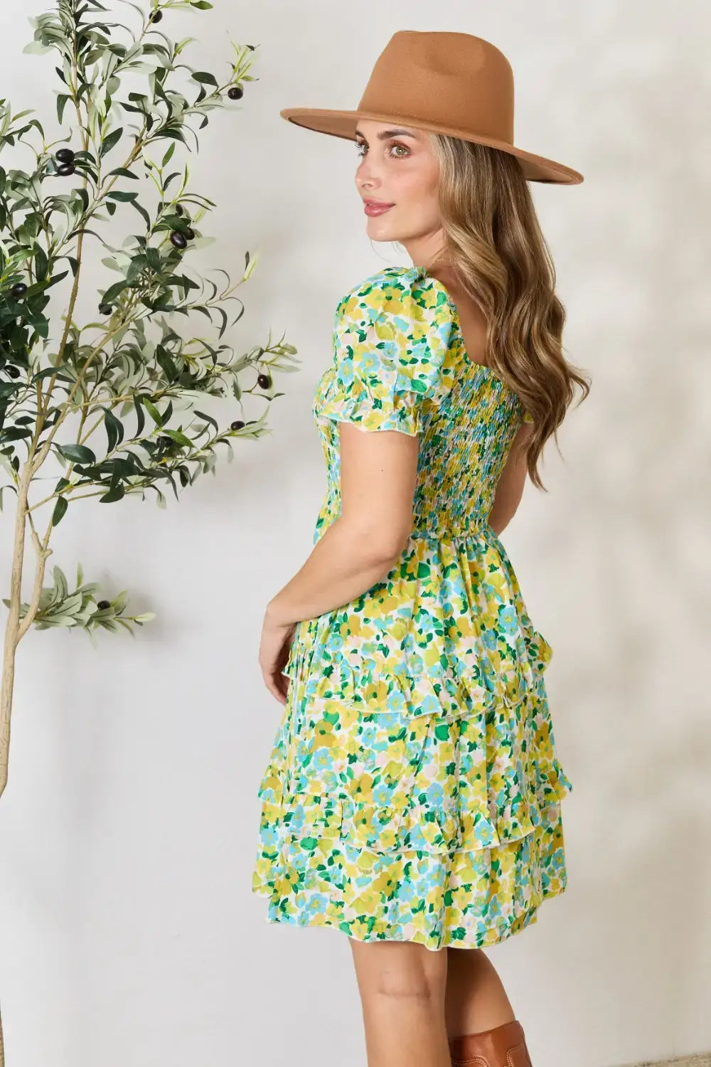 Woman wearing a Devine Smocked Scoop Neck Mini Dress with floral pattern and tiered ruffles