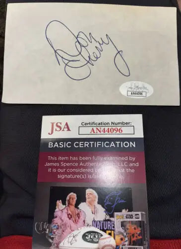 Autographed Ric Flair memorabilia alongside Don Cherry signed Boston Bruins hockey auto
