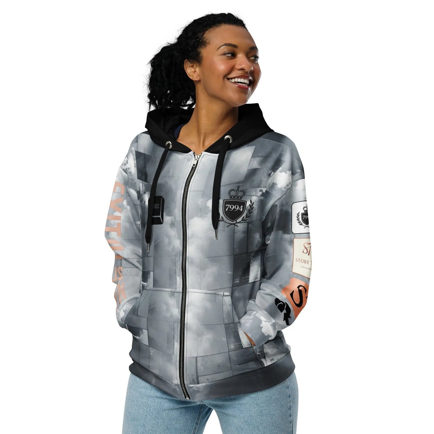 Woman wearing gray and black exit illusion hoodie with light blue jeans and dark hair