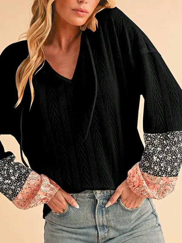 Black floral patchwork long-sleeve top with V-neckline and floral print cuffs