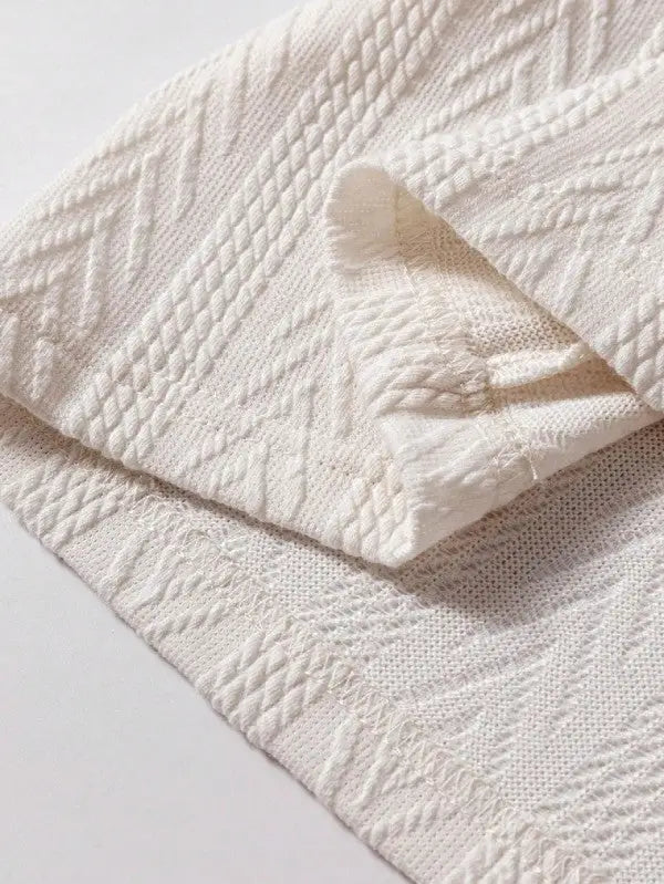 Cream-colored knitted blanket with a textured pattern, perfect for floral patchwork decor