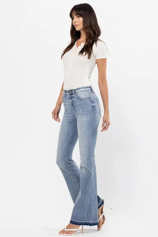 Light wash high rise flare denim jeans with distressed raw cut hem and bottom detail