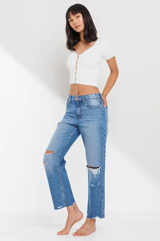 Young woman in white ribbed crop top and distressed blue jeans showcasing High Rise Straight Leg Ankle Jean