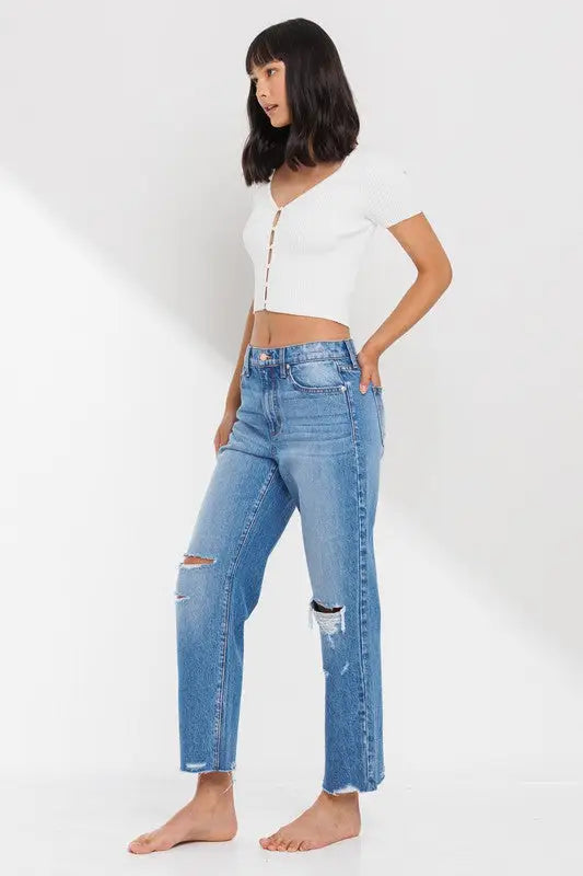 Young woman in white crop top and distressed jeans showcasing High Rise Straight Leg Ankle Jean