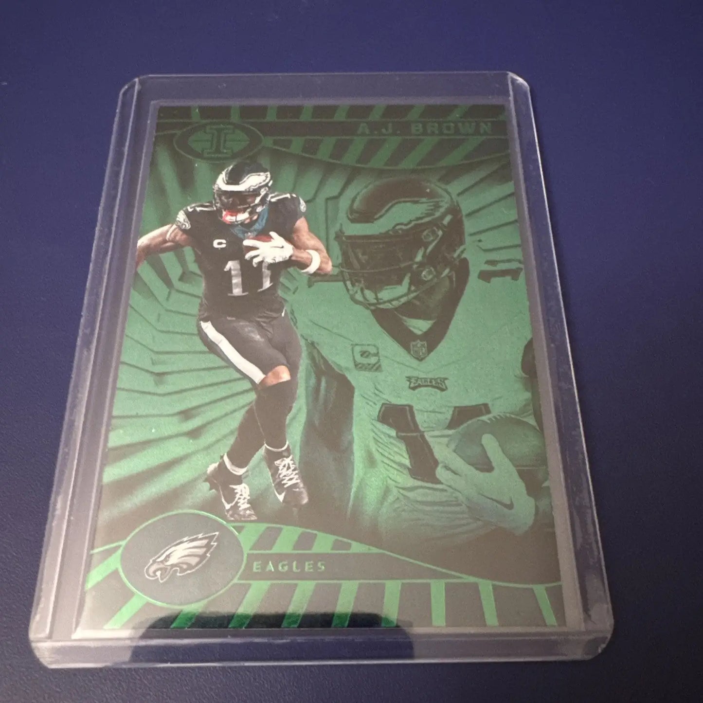 Philadelphia Eagles A.J. Brown football trading card in protective sleeve from Panini Illusions Emerald set with base color match featuring Jalen Hurts