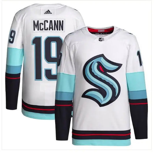 White Seattle Kraken hockey jersey with blue teal accents and MCCANN 19 logo