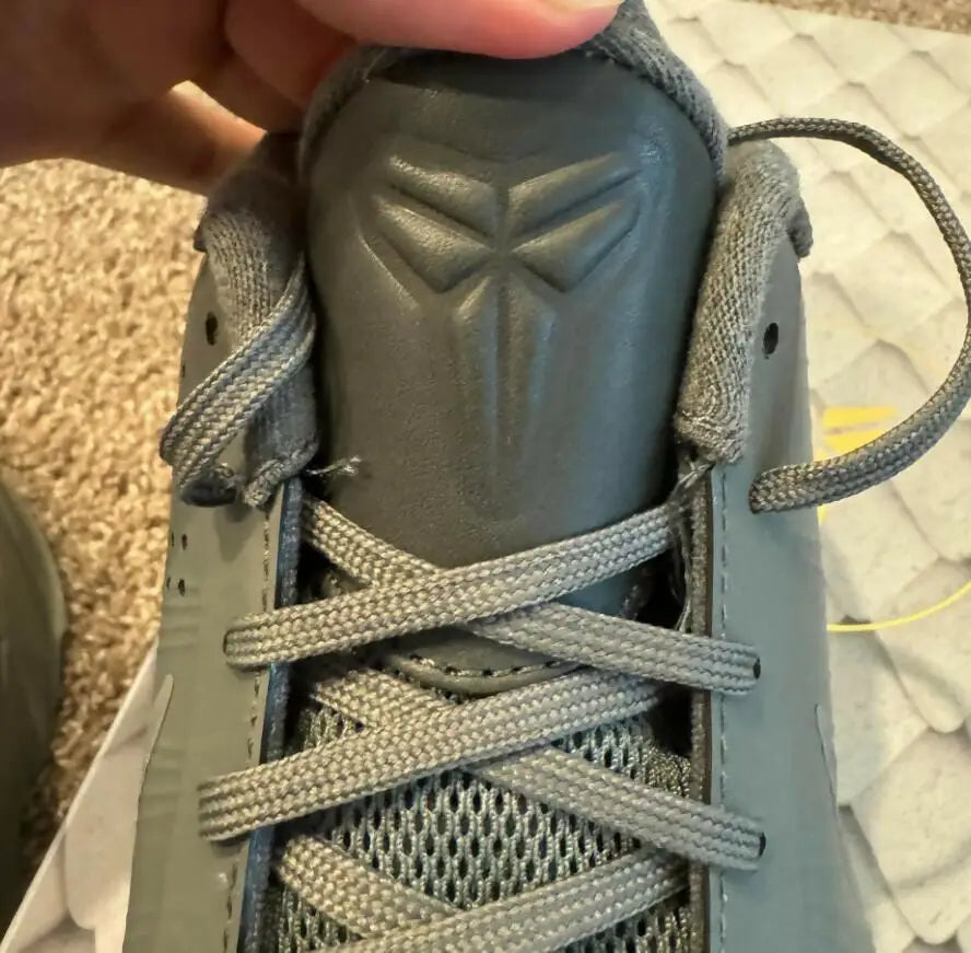 Close-up of Grey Kobe 5 Fade To Black athletic shoe with textured tongue and logo