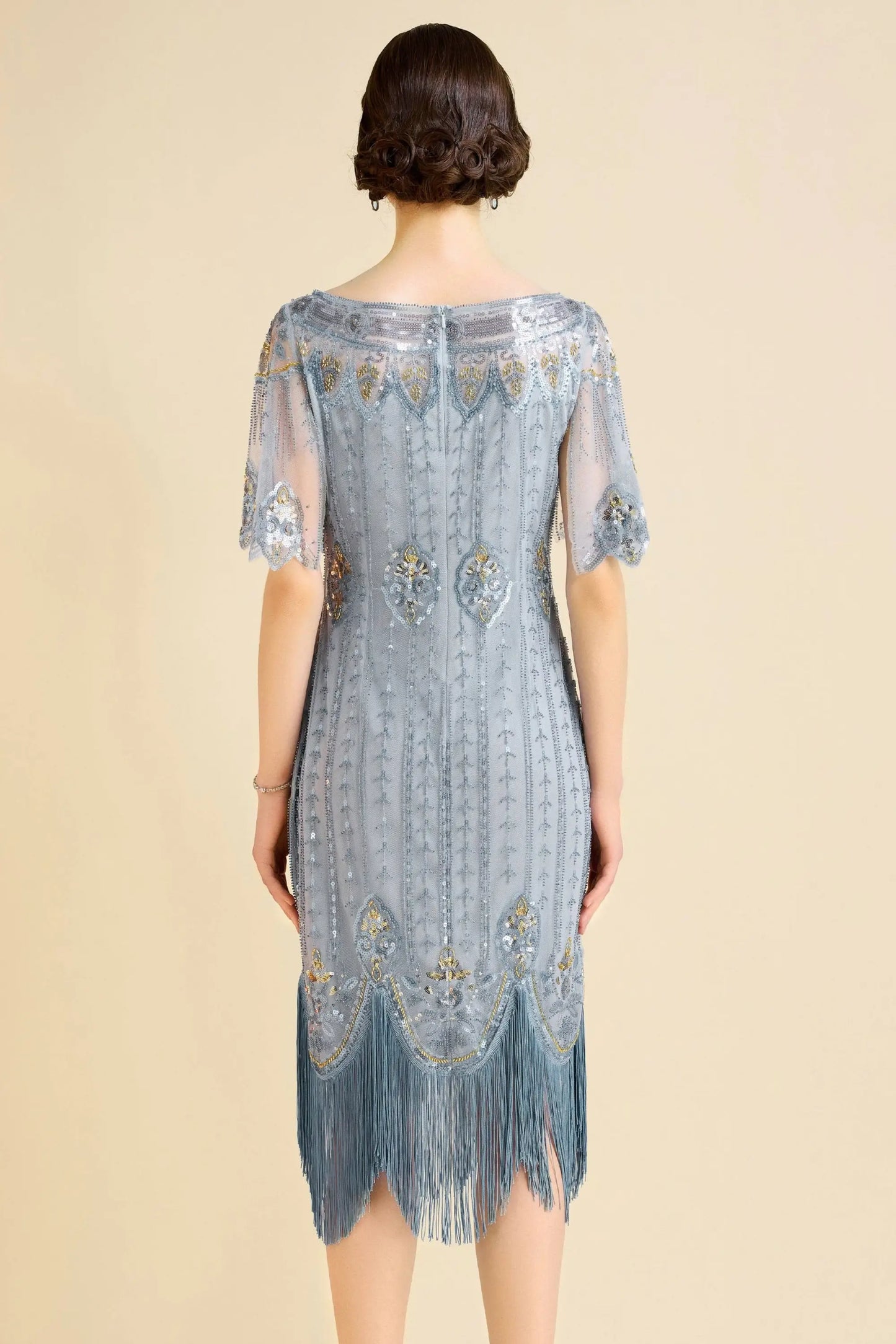 Woman modeling sky blue beaded flapper dress with fringe and boat neck for cocktail event