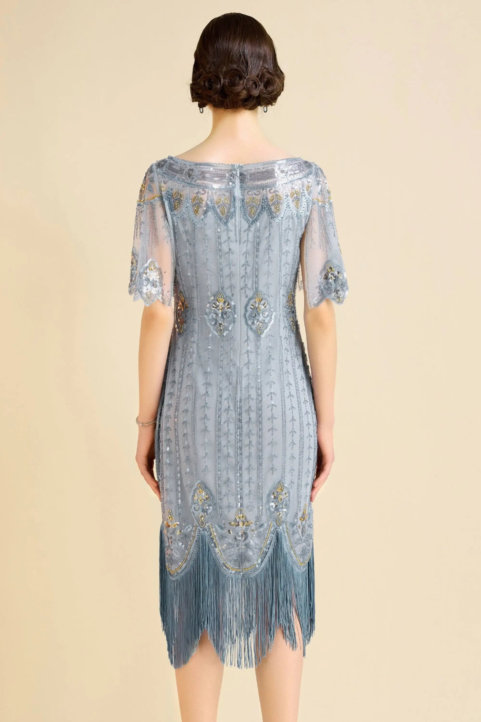Woman modeling sky blue beaded flapper dress with fringe and boat neck for cocktail event