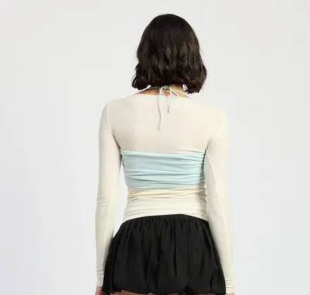Woman wearing beige long sleeve top with light blue ruched bandeau, trendy apparel SM Med LG