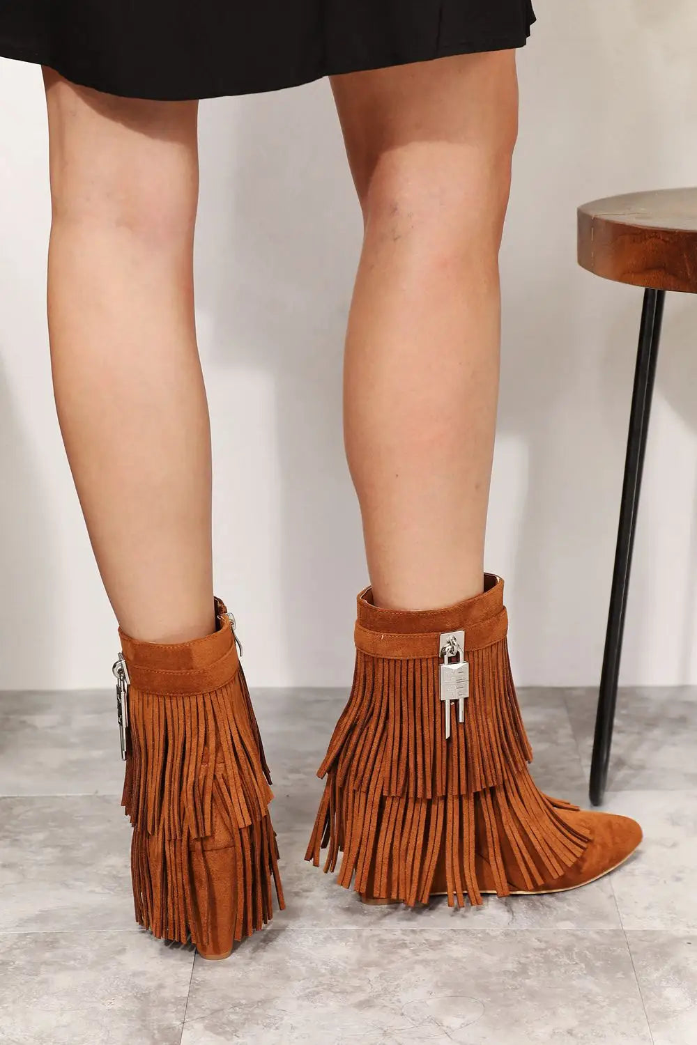 Tan suede ankle booties with fringe, zipper detail, silver hardware, and wedge heel
