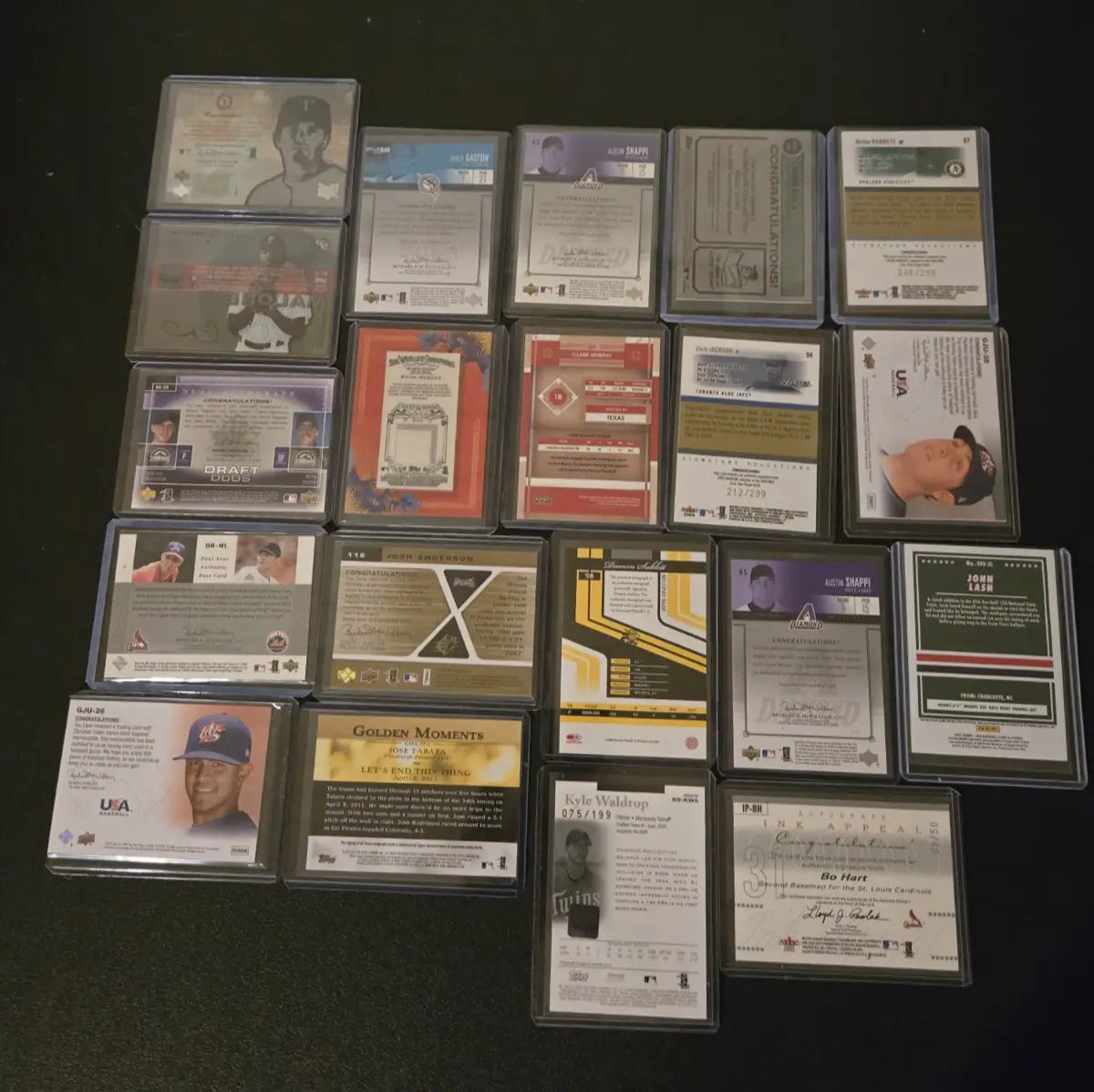 Collection of baseball trading cards in protective sleeves featuring Aaron Nola and Kyle Waldrop