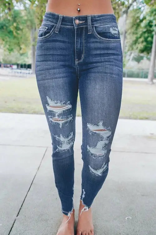 Relax in these distressed dark wash skinny jeans with raw hem, perfect for business days