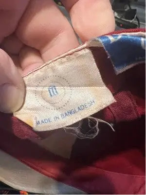 Red fabric garment with white care tag for Men’s Drew Pearson Alabama Tide baseball cap