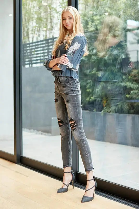 Young woman wearing Mid Rise Skinny with Destroy ripped jeans and high heels