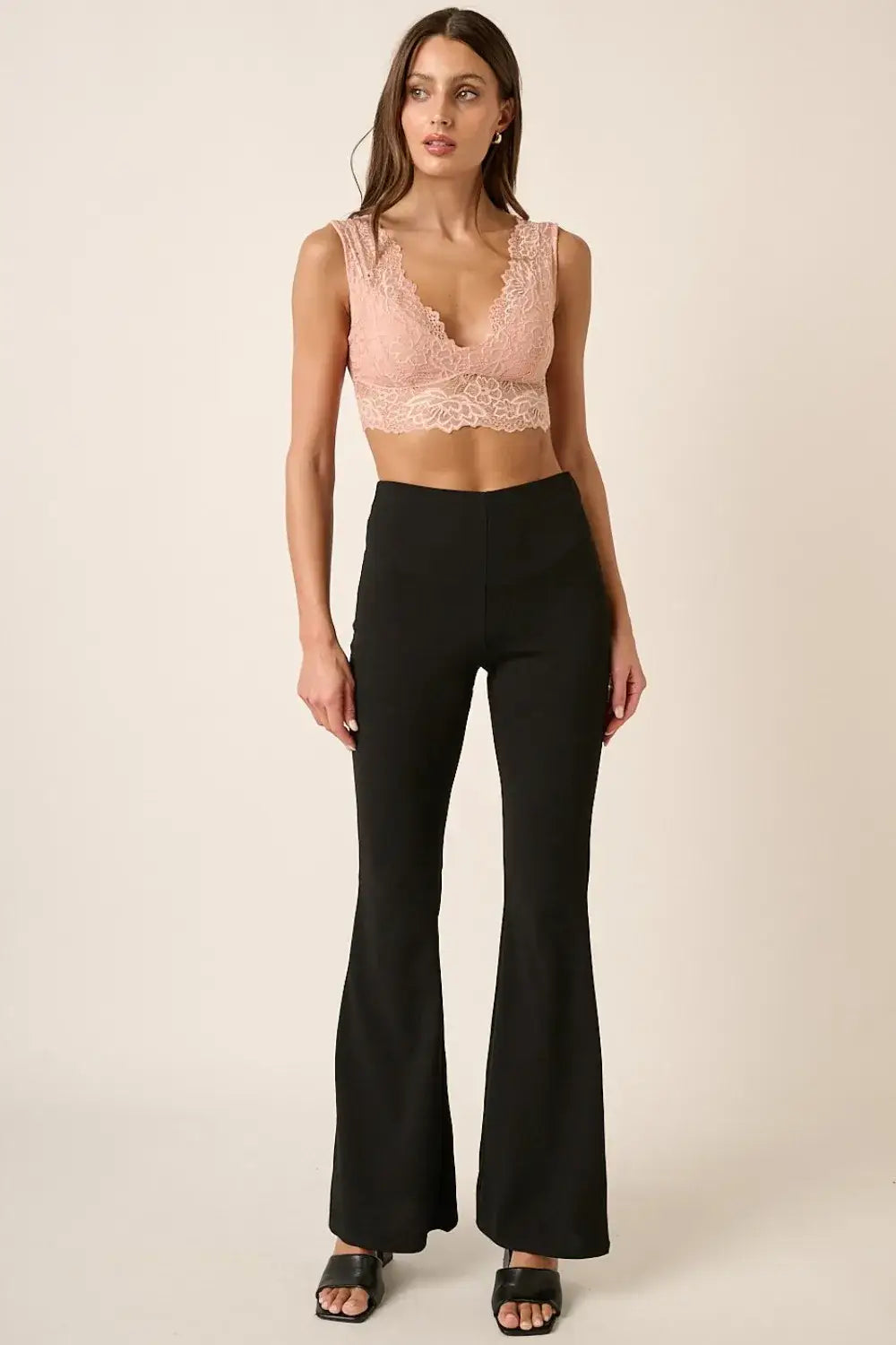 Black crepe knit flare leg pants with high waist, paired with lace crop top and open-toe sandals