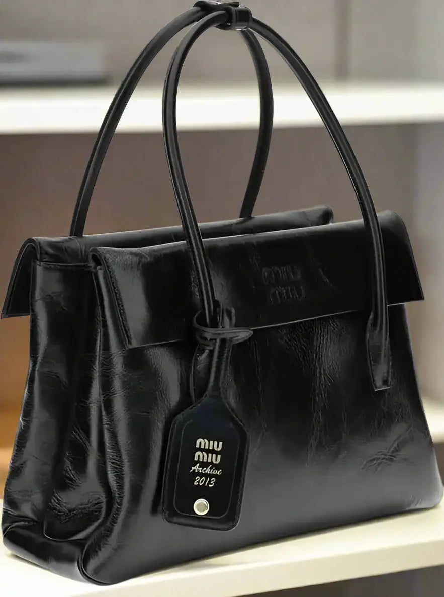 Shiny black leather Miu Miu solitaire handbag with top handles and detachable tag