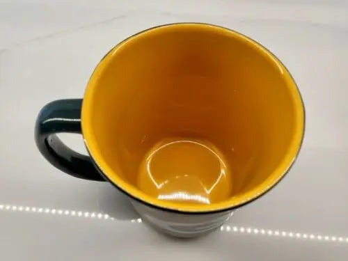 Yellow-lined dark-handled Green Bay Packers ceramic coffee mug featuring Green Bay logo