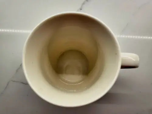 Empty off-white Bone China coffee mug featuring New Orleans Saints logo