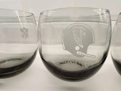 Gray stemless glasses with etched NFL Vintage Atlanta Falcons logos, smokey Rolly Polly design