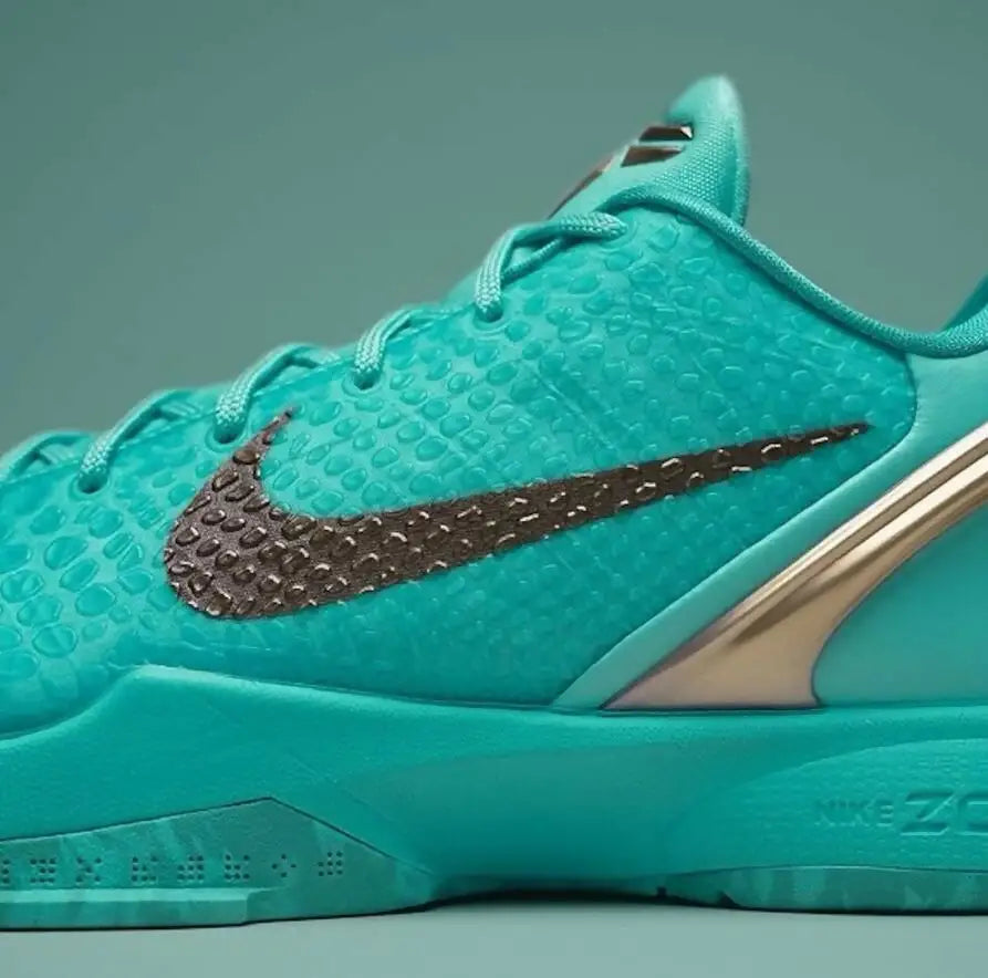 Teal Nike Kobe 6 Statue Of Liberty athletic shoe with textured upper and gold accents